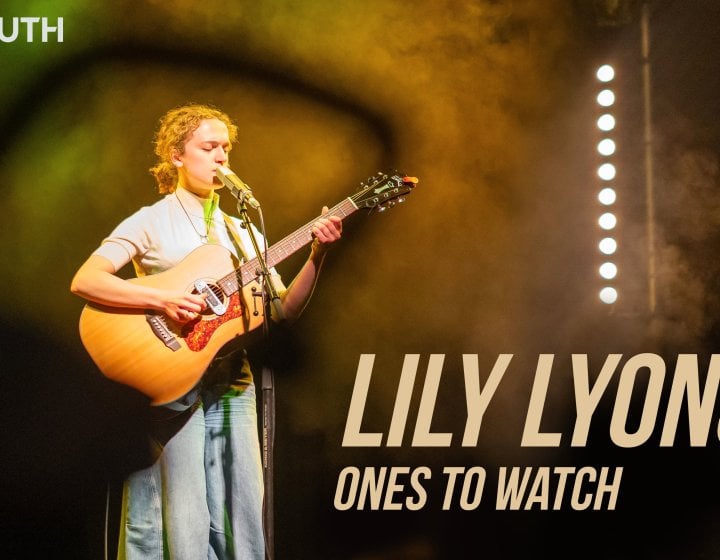 A woman playing a guitar on a stage 
