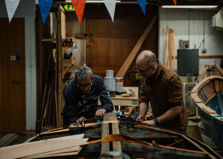 Two men building a boat
