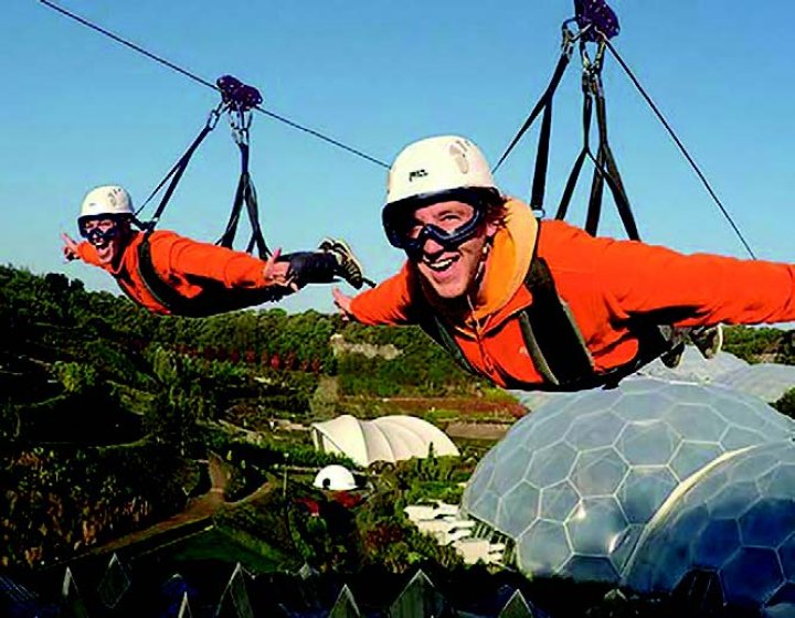 Two people on a zip line above The Eden Project