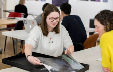 Falmouth University student showing photography portfolio to lecturer.