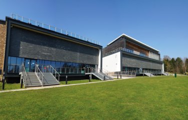 Exterior of the AMATA building on Penryn Campus with grass and blue sky