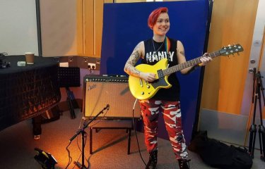 Harri Betsworth performing with her guitar