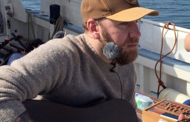John Lamb singing on a boat for his latest album.