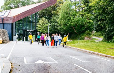 a student showing a group of people around Falmouth University campus at an Open Day