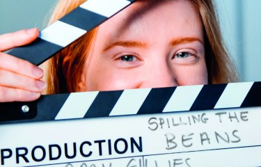 Student, Amy Gillies, peeking though a clapperboard.