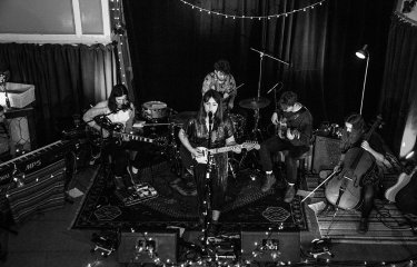 Music students playing instruments in a band with fairy lights
