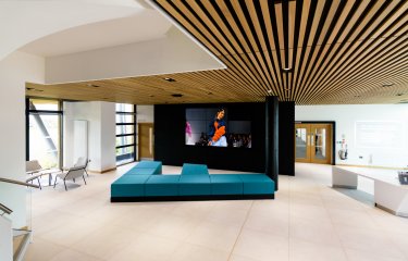 Open plan event space with large screen minimalist design and seating at the Creative Bridge 