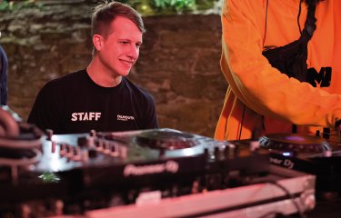 A Creative Events Management student sat behind a music desk