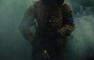An airsoft player emerging from smoke 