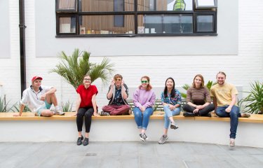 Student smiling and sitting on wall in Fox cafe.