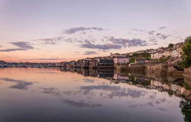 Buildings on the edge of the water with a purple sky