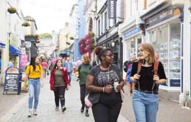 Group of students walking through Falmouth high street.