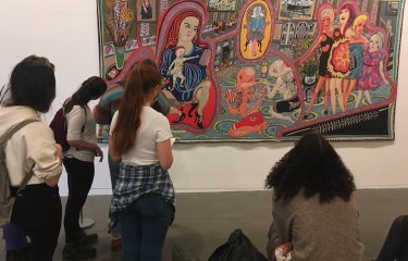 Falmouth University Illustration students looking at a large tapestry by artist, Grayson Perry
