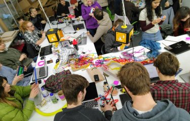 A group of Falmouth University students around a table with string and objects