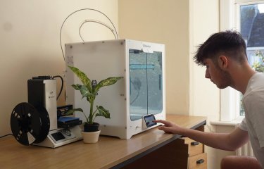 A Falmouth University Sustainable Product Design student with a 3D printer