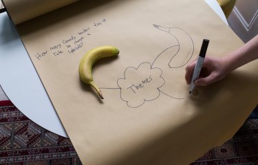 A large brown roll of paper with themes written in the centre and a banana
