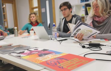 Falmouth University MA Graphic Design students at a table