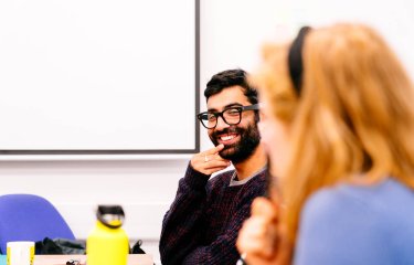 Two students sat together discussing Illustration