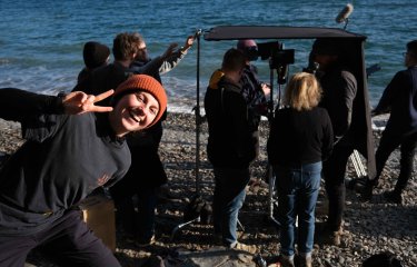A student poses in front a camera crew on set 