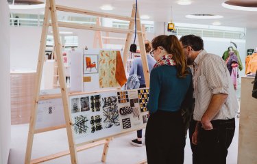 A father and daughter looking at an art exhibition at Falmouth University