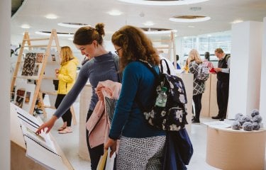 Mother and daughter at a Falmouth University open day looking at art work.