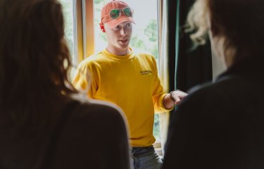 Student ambassador stood in front of window talking to group.