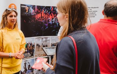 A Falmouth University student ambassador talking to a girl wearing a navy jacket