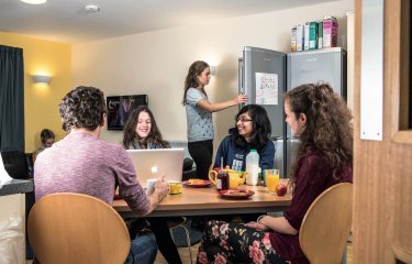 A group of Falmouth University students sat round a table having breakfast in university halls