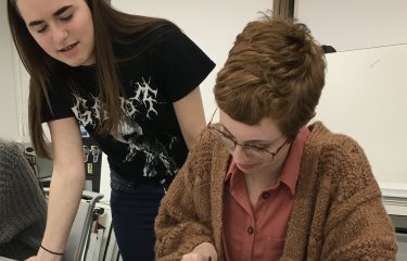 Student Hollie Milne making a model with fellow student looking on