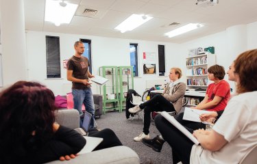 A Falmouth University student stood up presenting to other students in a seminar