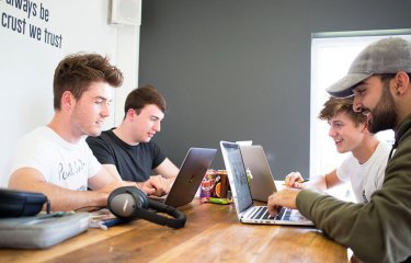 Business students working on laptops