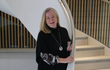 Professor Anne Carlisle in front of a staircase