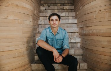 Falmouth University alumni Tom Raffield sitting on wooden steps