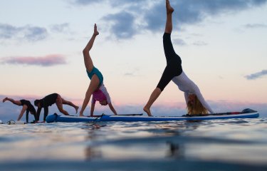 Falmouth University students doing yoga on paddle boards