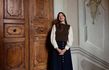A woman stood in front of a large wooden door