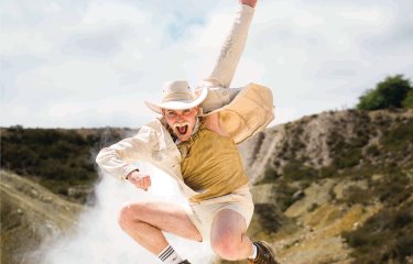 A person dressed as a cowboy jumping in the air in a disused Cornish mine