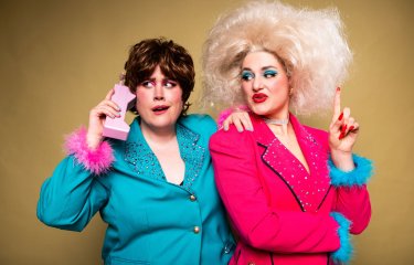 Two brightly coloured dressed people posing for the camera