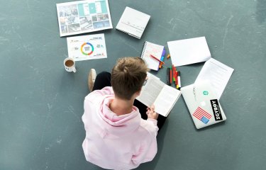 Student sitting on floor working on a project