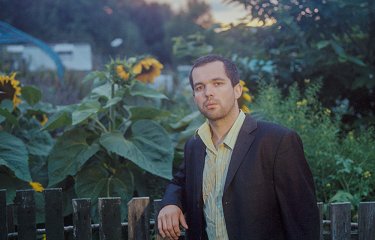 Benjamin Woods of band The Golden Dregs leaning on a fence 