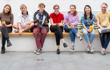Students sitting on a wall