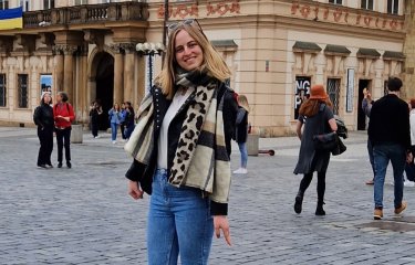 Master's student Inge stood outside a large building
