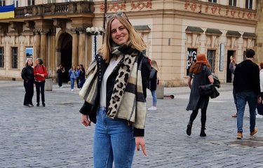 Master's student Inge stood outside a large building 