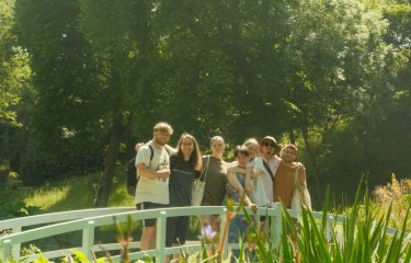 Falmouth students posing on a bridge in a garden