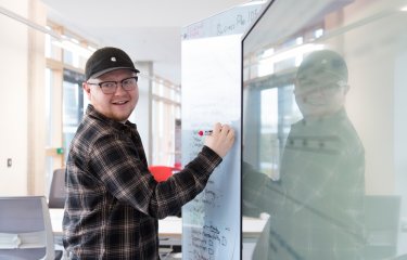 Falmouth University Sustainable Business student writing on a white board