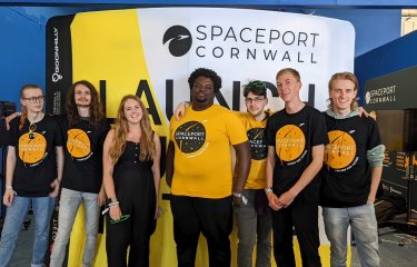 A group of students stand shoulder to shoulder wearing 'Spaceport Cornwall' tshirts