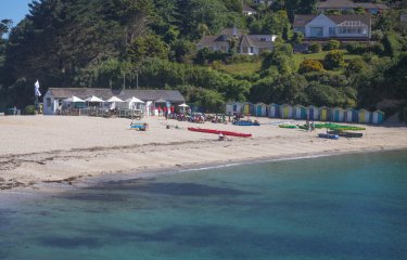 Swanpool Beach from the water with the beach, cafe and beach huts in the background