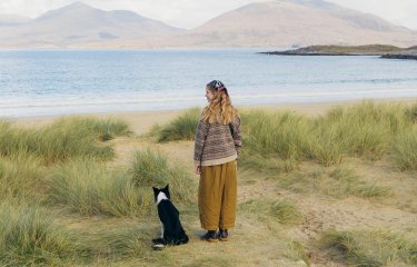 Woman and dog looking out to sea