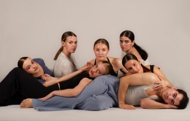 A group of dancers either lying or sitting on the floor
