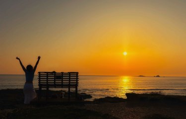 A sunny image with a person next to a bench