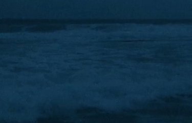 A dark image of waves with the text "Surveil" split across the top and bottom of the image